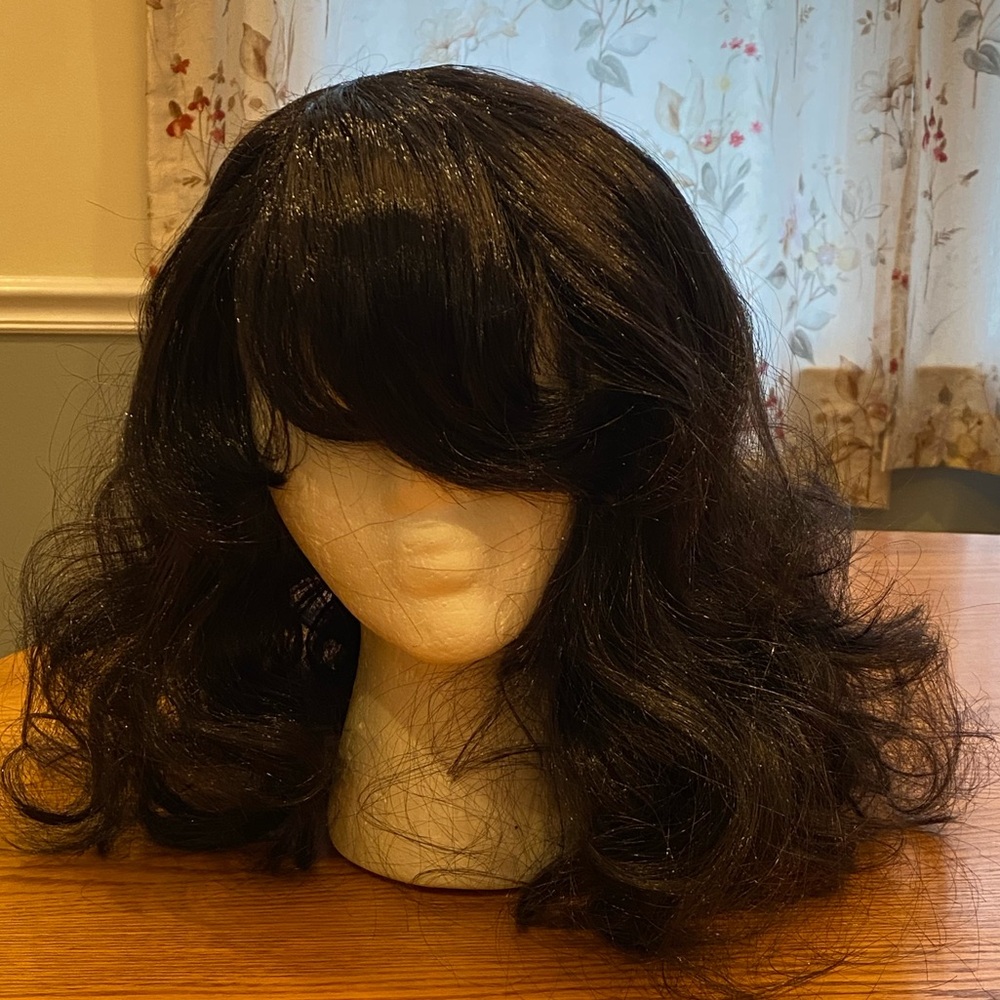 A mid-length wavy/curly black cosplay wig.